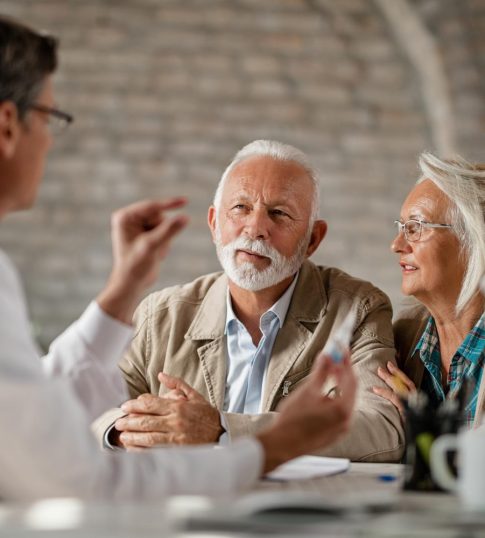 senior-couple-communicating-with-doctor-about-their-healthcare-insurance-plans-clinic